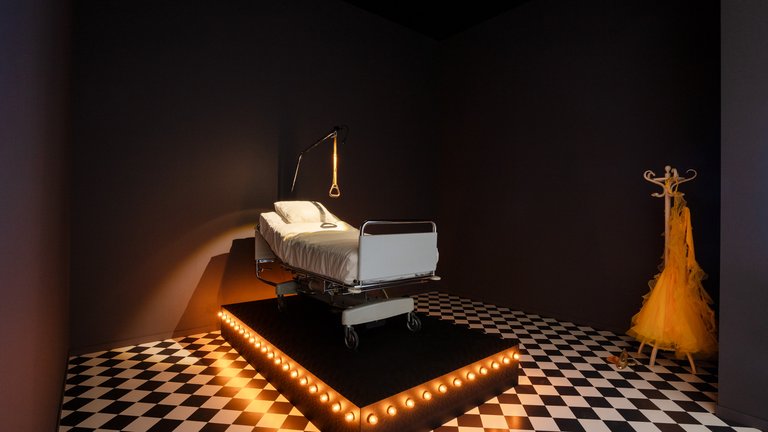 Hospital bed in a dark room, photograph from an installation titled 'Laughing Gas'