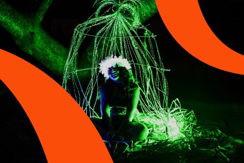 Summer Showcase 2019 branding over an image of a person sitting in the dark with neon green light shining on them